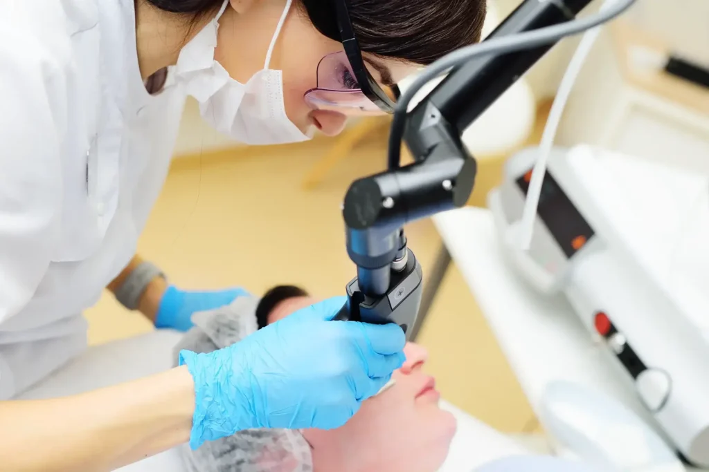 a woman using a microscope to remove a person's eyes